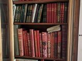 a book shelf with many books and candles in it