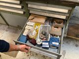 un homme qui ouvre un tiroir rempli d'objets