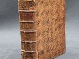 an old book sitting on top of a table next to a gray background
