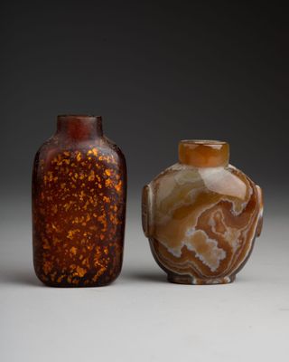 une paire de vases marron et blancs posés l'un à côté de l'autre sur une surface blanche