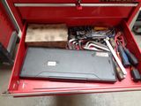a red tool box with tools in it on the floor