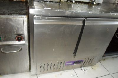 une cuisine sale avec une pile de vaisselle sale sur le plan de travail