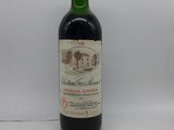 une bouteille de vin rouge posée sur une table blanche