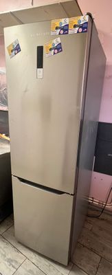 un réfrigérateur argenté dans une cuisine aux murs roses