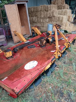 un tracteur garé dans l'herbe près du foin