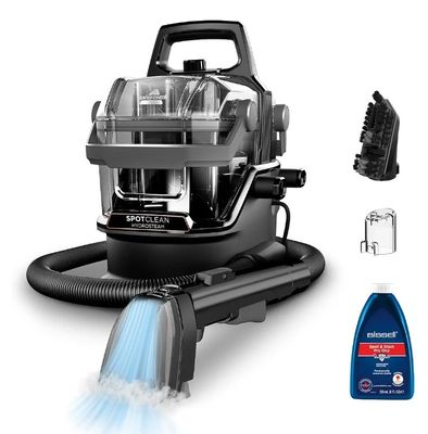l'aspirateur noir et argent se trouve à côté d'un flacon de produit nettoyant