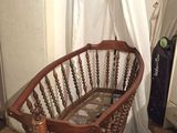 un fauteuil à bascule dans un coin d'une pièce où se trouve un rideau blanc
