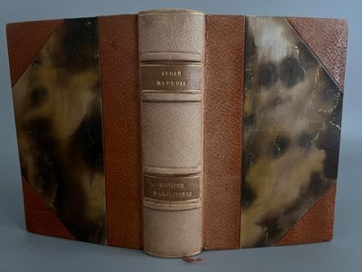 un vieux livre à la couverture marron posé sur une table