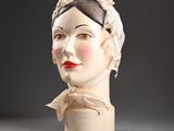 une tête de femme en céramique, coiffée d'un foulard