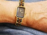 a woman wearing a gold watch on her wrist
