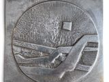 an image of a metal plaque with a hand holding a cross on it