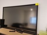 a flat screen tv sitting on top of a wooden shelf