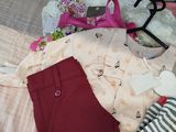 a pile of clothing on a bed next to a stuffed animal