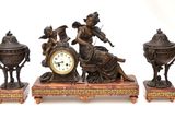 trois figurines en bronze posées sur une table en bois