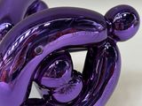 a purple balloon shaped like a dog sitting on a table