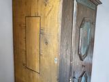 a tall wooden cabinet with a clock on top of it