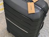 a black suitcase with a tag on it sitting on the ground
