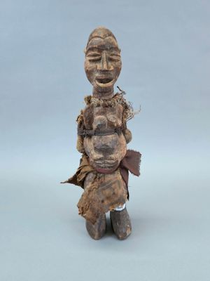 un gros plan sur une statue en bois représentant une personne avec un bébé