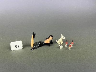 a miniature figure of a woman sitting on a table next to a number