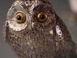 a silver owl figurine sitting on top of a table