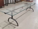 an image of a glass table with metal legs in a room