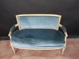 a blue couch with gold trim and a black background