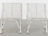 pair of white wicker chairs in the style of person