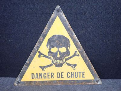 un panneau d'avertissement sur lequel figure une tête de mort entourée d'os croisés