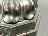 a bronze statue of a man with a hat on it ' s head