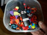 a person holding a plastic container filled with assorted items