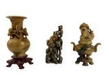 trois figurines en bronze représentant un homme et une femme, posées sur un socle