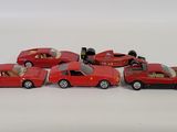several toy cars are lined up in a row on a white surface