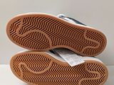 the soles of a pair of blue and white shoes on a white surface