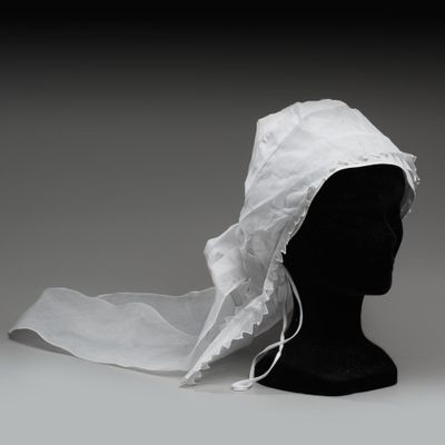 une tête de mannequin noire recouverte d'un tissu blanc