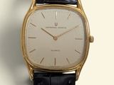 a close up of a gold watch with a black strap