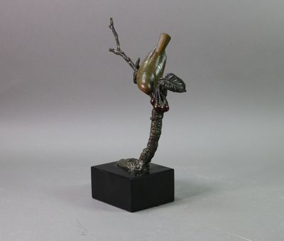 a statue of a bird perched on a tree branch