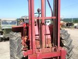 un chariot élévateur rouge garé sur le bord de la route