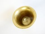 a gold vase with a small ball inside of it