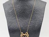 un collier en or orné d'un crâne et d'une croix, porté par un mannequin