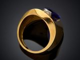 a close up of a gold ring with a blue stone