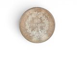 an old silver coin on a white surface with a white background