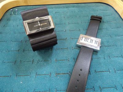 deux montres posées l'une à côté de l'autre sur un tapis bleu