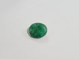 a close up of a green jade stone on a white surface