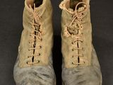 two pairs of boots with laces on them sitting on a black surface