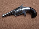 a close up of a revolver on a brown background