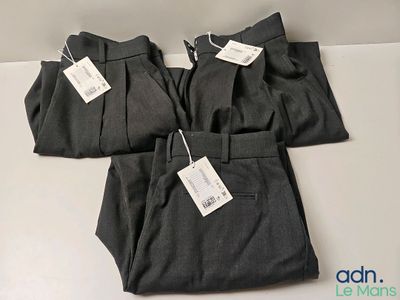 two men ' s pants with tags on them sitting on a table