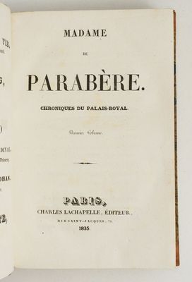 un livre ouvert posé sur une table à côté d'un mur blanc