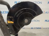 a close up of a wheel on a vehicle with a sign in the background