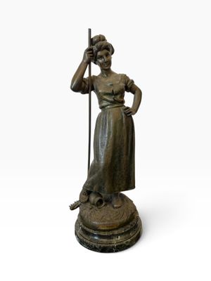 bronze statue of a woman holding a staff and standing on a pedestal
