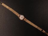 an image of a watch on a black surface with a black background